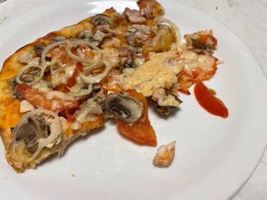 Taze pişmiş, altın kenarlı bir pizza, metal bir fırın tepsisinin üzerinde duruyor..