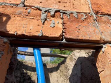 Sıraların arasında yatay çelik destek çubukları olan katmanlı tuğla duvar ustası..