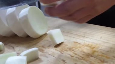 Bir restoranın mutfağında ustalıkla daikon turpları ve pırasaları keserken bir şefin ustalığını izleyin. Bıçak yeteneklerini sergiliyorlar.