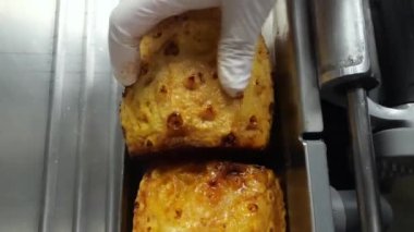 Fırınlanmış ananasın hassas dilimlenmesi. Fırında pişirilmiş ananası dilimleme sanatı bir tabakta güzel duran ince ve lezzetli dilimler yaratmak için bir dilimleyici kullanır..