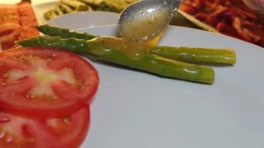 Sebzelerin gurme restoranı sunumu. Renkli domatesler, kuşkonmaz, ananas, biber, karnabahar, marul ve diğer taze sebzelerin çarpıcı bir şekilde bir araya geldiği bir restoranda sanatla sunuluyor.