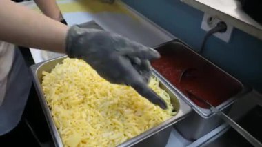 Üzerinde yabanmersini reçeli olan pizza hamuru ustalıkla şekillendirilmiş. Domates ezmesi, peynir ve sosis eklenir..