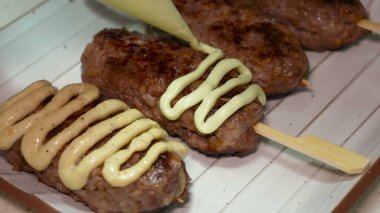 Lula kebabı ahşap şiş, çeşitli soslarla süslenmiş, doğranmış fındık serpiştirilmiş, balık havyarı ve diğer atıştırmalıklarla tamamlanmış..