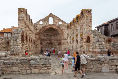 NESSEBAR, BULGARIA - 17 Haziran: Turistler Bulgaristan 'ın Karadeniz kıyısındaki UNESCO Dünya Mirası Sahasındaki Nessebar eski kentinde Aziz Sofya Kilisesi (eski Piskopos) etrafında yürüyorlar.