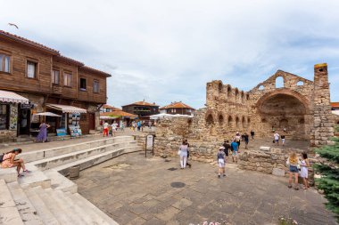 NESSEBAR, BULGARIA - 17 Haziran: Turistler Bulgaristan 'ın Karadeniz kıyısındaki UNESCO Dünya Mirası Sahasındaki Nessebar eski kentinde Aziz Sofya Kilisesi (eski Piskopos) etrafında yürüyorlar.