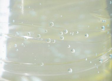 Gaz arka planında Macro Bubbles olan su. Plastik şişede sıvı şeffaf içecekle ıslatılmış soyut renk şablonu. Poster, bayrak, kartpostal, broşür için taze ve soğuk hava arkaplanı.