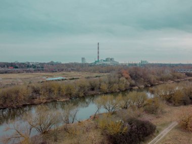 Aerial view of factory with forest and river