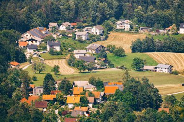 Tarlaları, ağaçları ve evleri olan bir köy. Görüntü: Sveti Jakob Tepesi