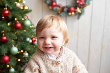 Noel Baba bebek. Güzel çocuk. Mutlu Noeller ve mutlu yıllar. Noel ağacı arka planı