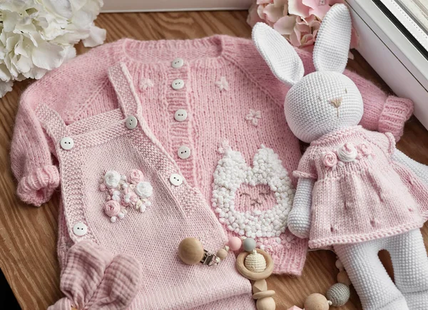 Baby knitted clothes and toys. Handmade knitted clothes with embroidery