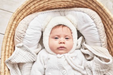 Baby lying in wicker cradle. Happy Mother's and Father's Day. Childhood and parenthood.