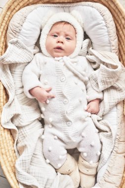 Baby lying in wicker cradle. Happy Mother's and Father's Day. Childhood and parenthood.