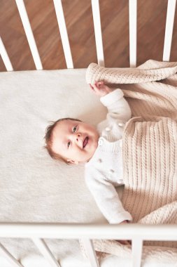 Baby lying in bed. Happy Mother's and Father's Day. Childhood and parenthood.
