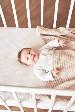 Baby lying in bed. Happy Mother's and Father's Day. Childhood and parenthood.