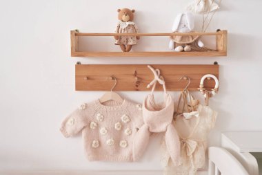 Baby knitted clothes on hanger. Preparation for childbirth