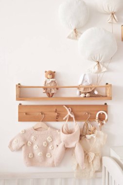 Baby knitted clothes on hanger. Preparation for childbirth