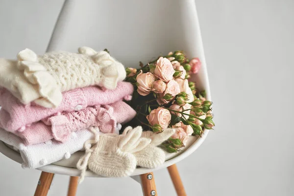 Warm knitted clothes and flowers. Knitted clothes. Preparation for childbirth.