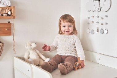 Çocuk odasında örgü elbiseli bir bebek. Çocuk odası..