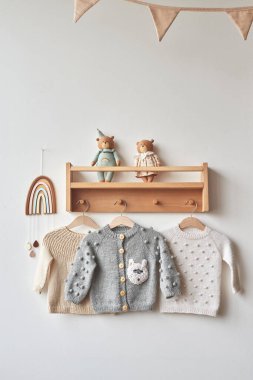 Askıda bebek kıyafetleri var. Çocuk odası..