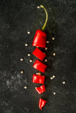 Siyah beton masa üzerinde kırmızı biber kağıdı karanlık ruh hali yiyecek konsepti  