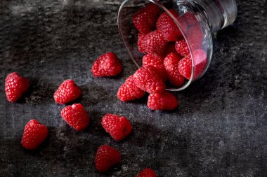 Taze ahududu ve ahududu siyah arka planda karanlık ruh hali yiyecek konsepti