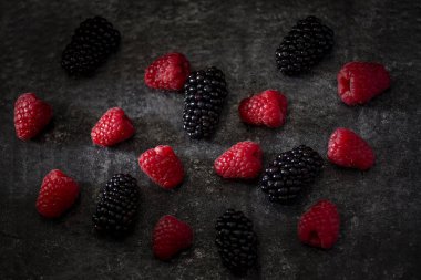 Siyah arka planda taze ahududu. Karanlık ruh hali yiyecek kavramı.