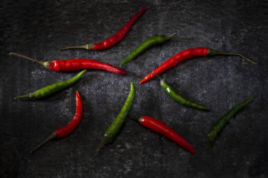 Siyah arka planda kırmızı kırmızı kırmızı biber. Karanlık ruh hali yiyecek konsepti.