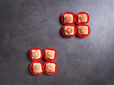 Top view of sushi roll pieces in gift paper pack. Sushi pieces with salmon on dark concrete background.