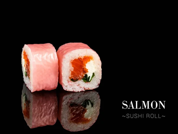 Close up to sushi roll pieces with mirror reflection on black background. Sushi roll with salmon, flying fish roe and rice paper on top. Ready menu advertising banner with text and copy space.