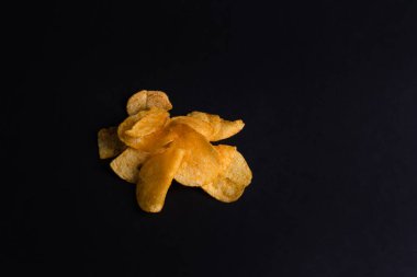 Spicy chips on black background, copy space