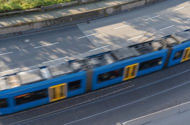 Hızla geçen bir tramvayla caddenin tepesinden bak.