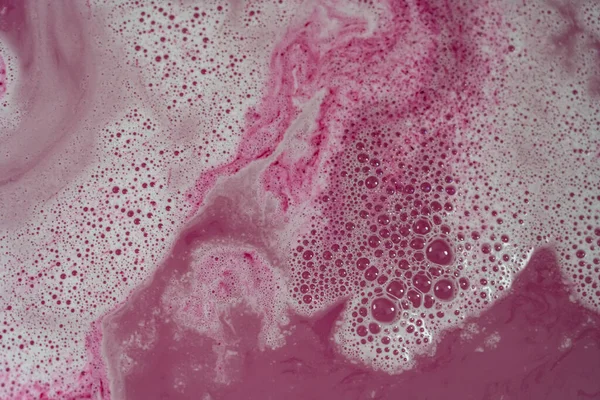 stock image Pink colored water with white foam and bubbles