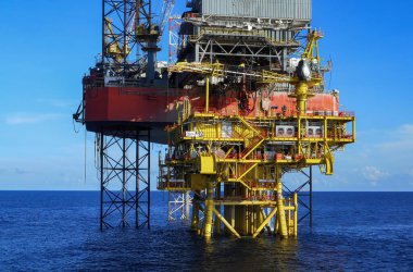 Açık deniz sondaj platformunda mavi gökyüzü arkaplanlı petrol kuyusu