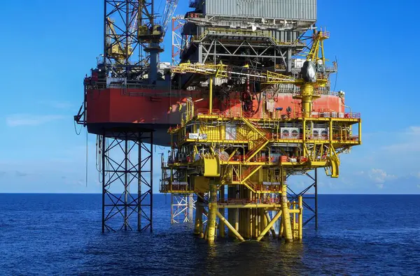 Açık deniz sondaj platformunda mavi gökyüzü arkaplanlı petrol kuyusu