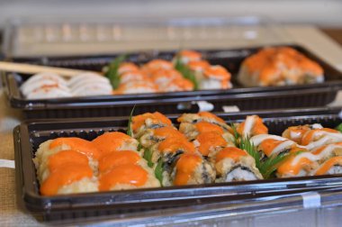 Çeşitli Japon yemekleri yakından izlenir. Asya suşisi servis edildi. Makro pozu yakın çekim. Japon deniz ürünleri restoranı. Pirinçli taze somon balığı. Geleneksel Japon yemekleri.