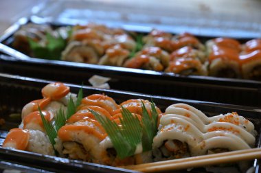 Çeşitli Japon yemekleri yakından izlenir. Asya suşisi servis edildi. Makro pozu yakın çekim. Japon deniz ürünleri restoranı. Pirinçli taze somon balığı. Geleneksel Japon yemekleri.