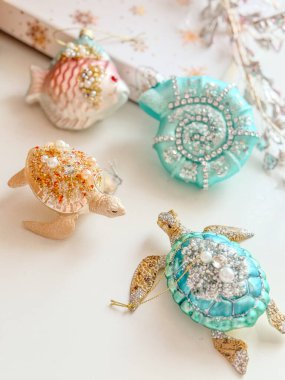 Beyaz arka planda modern Noel oyuncakları. Balık, kabuk ve kaplumbağa Noel süsleri..