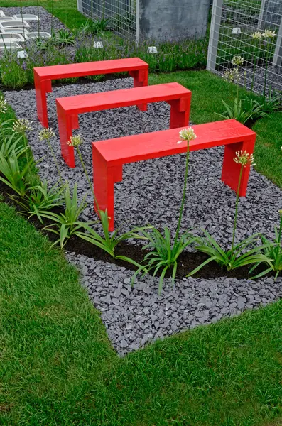 stock image A garden design based on ciphers and hidden meanings with picture showing bright red benches with Agapanthus