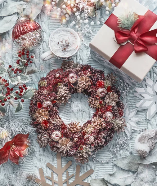 圣诞花环 带有老式圣诞装饰 礼物盒和一杯卡布奇诺在浅蓝色针织毛毯 顶部视图 度假公寓 — 图库照片