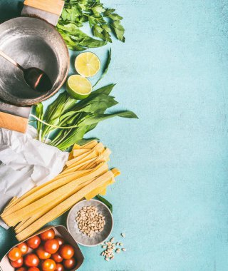 Yabani sarımsak ya da Ramson noodle malzemeleri: fettuccine, domates, çam fıstığı, limon ve mutfak masasının arka planında pişirme tavası, fotokopi alanı, üst görünüm. Mevsimlik gıda konsepti