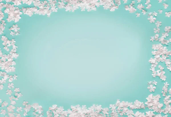 Прекрасная Рамка Маленьких Белых Цветов Бирюзовом Синем Фоне Вид Сверху — стоковое фото