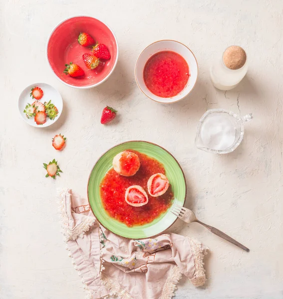 白いキッチンテーブルの上に緑のプレートに甘い果実のソースで新鮮なイチゴを詰めおいしいゆでたコテージ餃子 最上階だ 夏の甘い食べ物 家庭料理 季節の食事 ケンドリキ — ストック写真