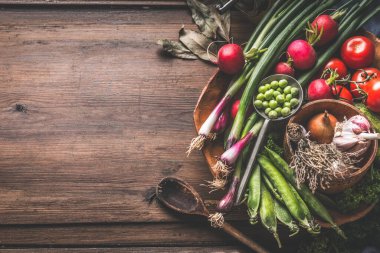 Baharatlı ve otlu ahşap masa üzerinde sağlıklı vejetaryen içerikli gıda arka planı. Tahta kasede organik sebzeler. Üst Manzara. Paleo diyeti. Vejetaryen. Mevsimlik sebzeler