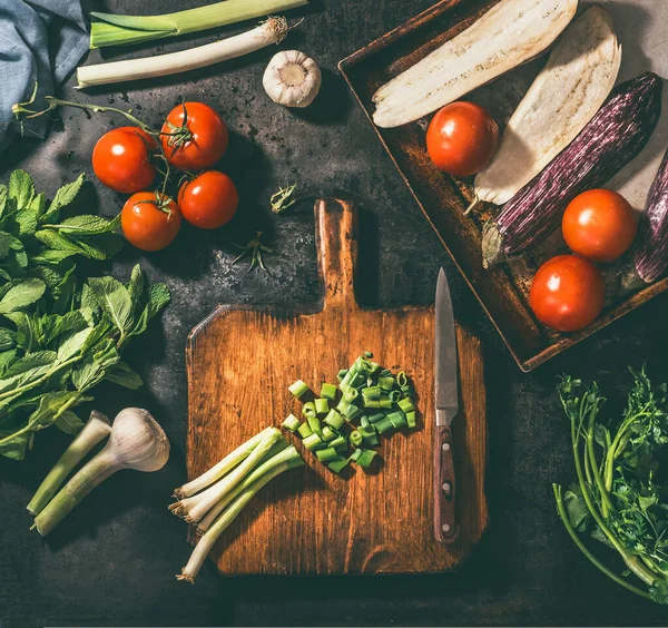 Vejetaryen, aşçı, konsept, doğranmış, malzemeler, ahşap, kesim tahtası, çeşitli, sebzeler, pırasa, domates, patlıcan, sarımsak, otlar, karanlık, kırsal, arka plan, üst görünüm