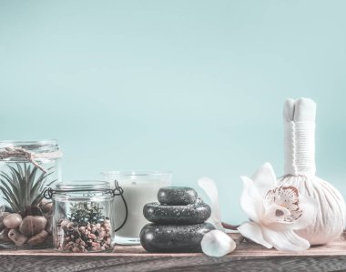 Zen taşları ve açık mavi arka planda masaj ekipmanları ile sağlık ve spa konsepti. Güzellik Günü