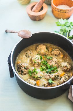 Sebze soslu vejetaryen karabuğday topları mutfak masasının arkasındaki tencerede. Kapatın. Sağlıklı ev yemeği konsepti