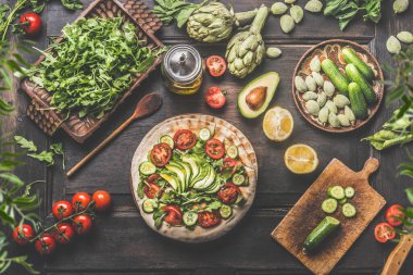 Healthy lunch making preparation. Tortilla wraps with fresh vegetables, avocado , olives oil and lemon on rustic wooden kitchen table , top view. Cooking preparation. Vegan food. Fresh ingredients