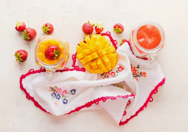 白いテーブルの背景にイチゴとマンゴースムージーとガラス瓶 トップビュー 健康的な果物やベリーの朝食 — ストック写真