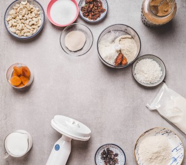 Gri beton arka planda kaju fıstıklı kek ve karıştırıcı için vejetaryen malzemeleri. Üst Manzara. Sağlıklı yiyecekler. Glütensiz diyet