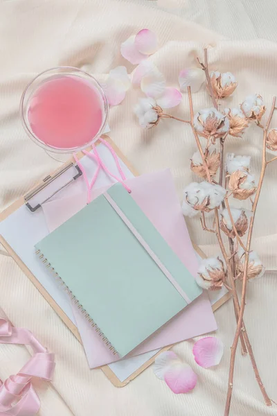 笔记本 棉花枝条和米黄色窗帘织物上的粉色饮品 顶部视图 现代美学平铺 — 图库照片
